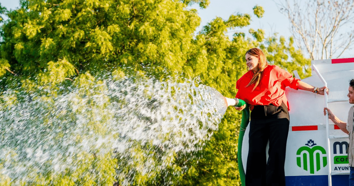 Mujer regando agua con pipa